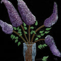 Bouquet of lilac flowers in a clear vase on a black background on 5 x 7 card