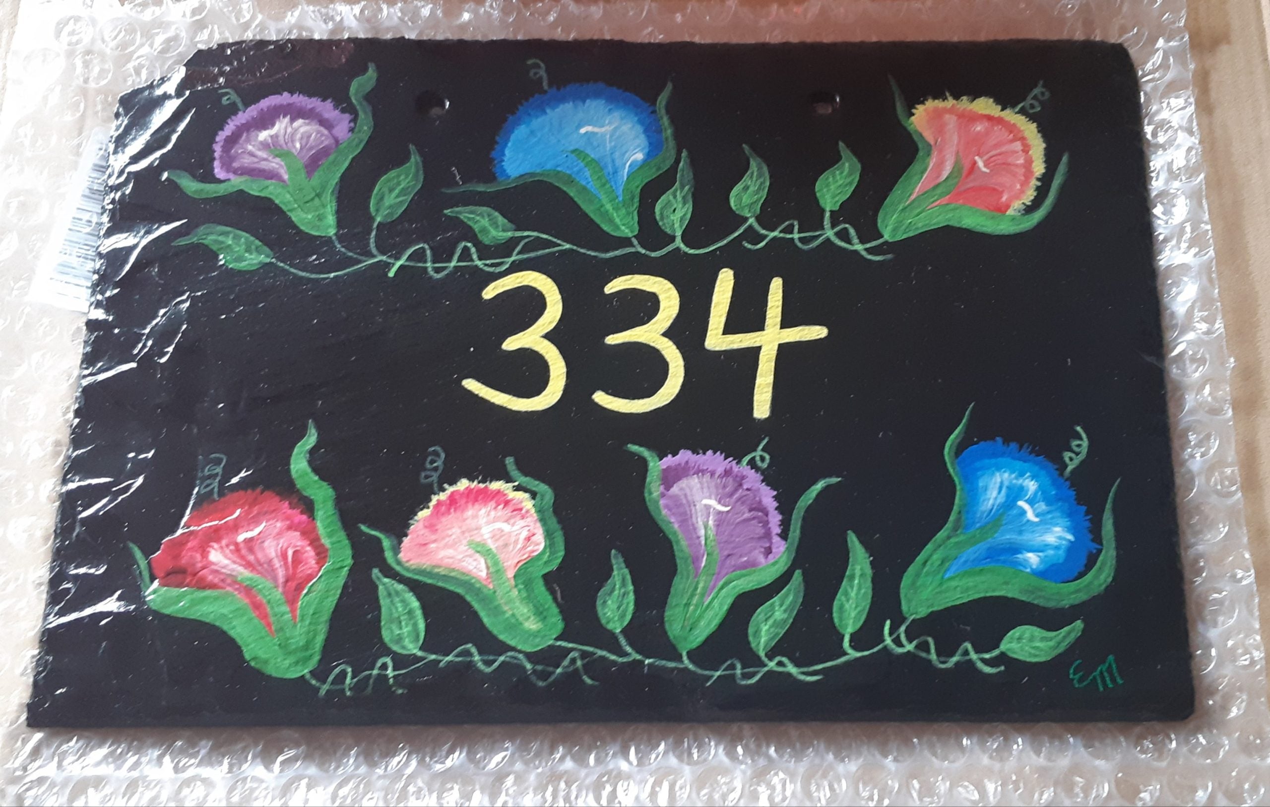 Slate sign with flowers and house number